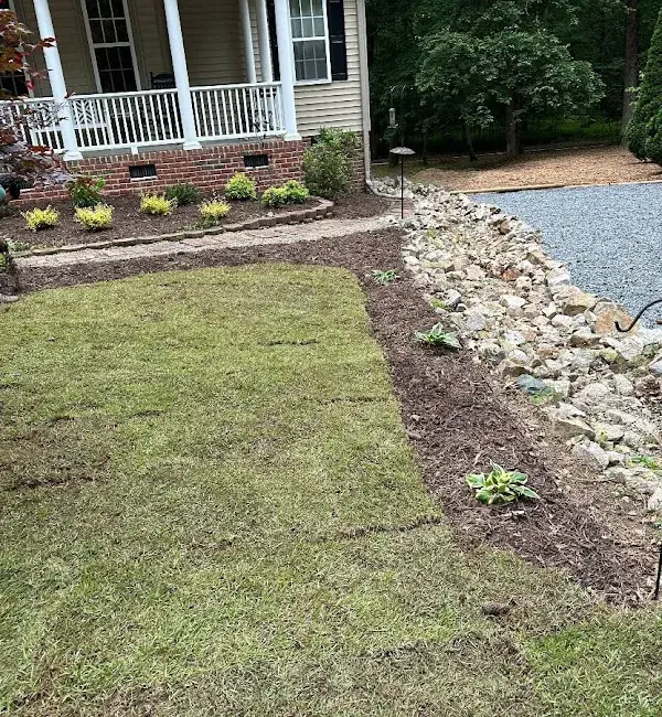 Residential front yard with brick walkway and mature landscaping