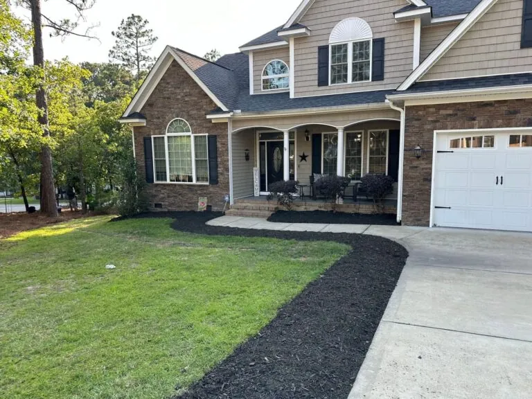 Completed front yard landscaping with fresh mulch and trimmed shrubs
