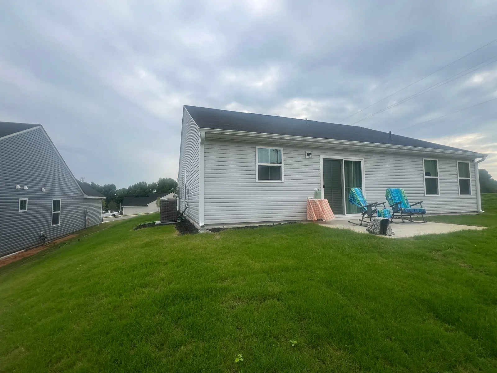 Thick, evenly mowed backyard lawn behind a new single-story home
